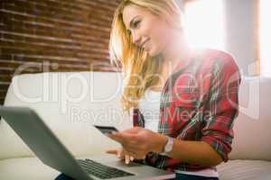 Pretty blonde using laptop on couch