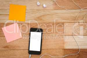 Post it and black smartphone with white headphones
