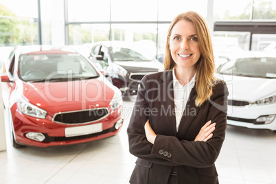 Smiling businesswoman standing with arms crossed