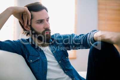 Unahppy man thinking on his sofa