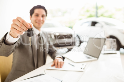 Smiling salesman holding a customer car key