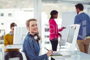 Graphic designer wearing headphones at desk