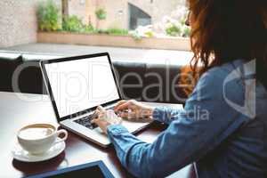 Mature student using laptop in cafe