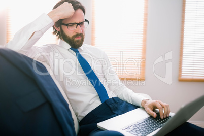 Businessman using laptop on the couch Businessman using laptop on the couch