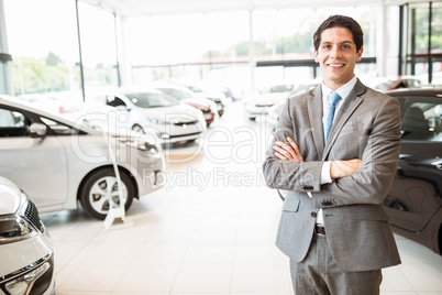 Smiling businessman standing with arms crossed