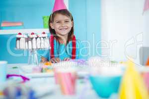 Smiling kid beside birthday cake