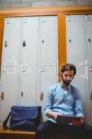 Hipster student using tablet in hallway