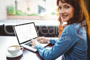 Mature student using laptop in cafe