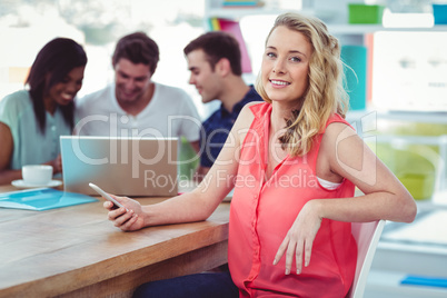Smiling creative businesswoman working with co-workers