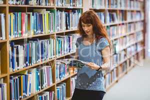 Mature student reading book in library wearing smart watch