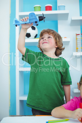 Small boy playing with a toy plane