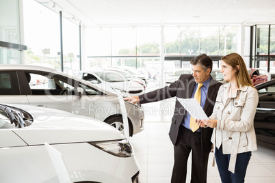 Salesman showing a car to a client