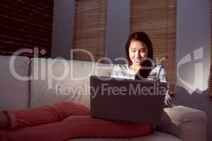 Asian woman using laptop at night