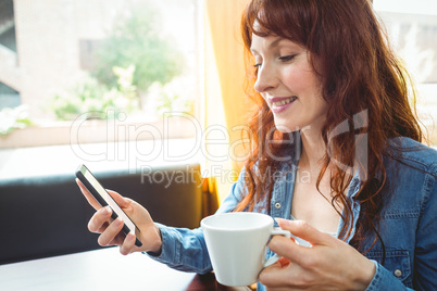 Mature student using phone in cafe