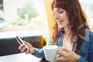 Mature student using phone in cafe