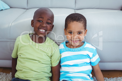 Smiling kids sitting by the couch