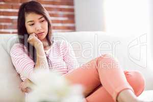 Upset asian woman on couch