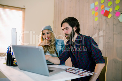 Creative team working at desk with laptop