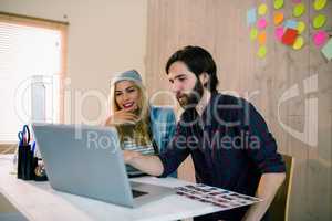 Creative team working at desk with laptop