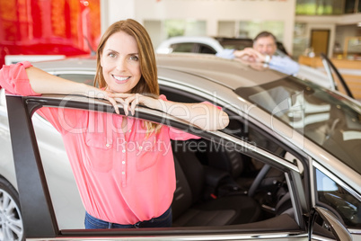 Smiling couple leaning on car