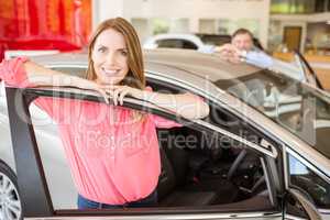 Smiling couple leaning on car