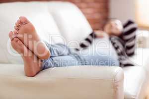 Asian woman lying on the couch listening to music