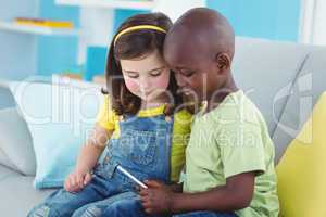 Smiling girl and boy using smartphone