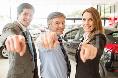 Group of smiling business team pointing together