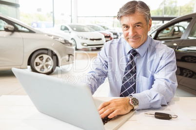 Smiling salesman behind his desk