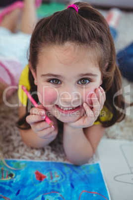 Smiling kid drawing pictures on paper