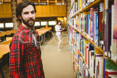 Hipster student picking a book in library