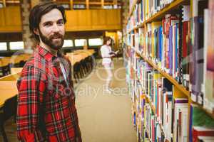 Hipster student picking a book in library