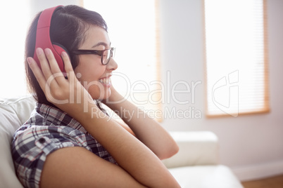 Asian woman on the couch listening to music