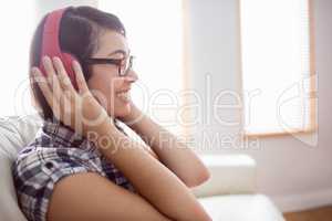 Asian woman on the couch listening to music