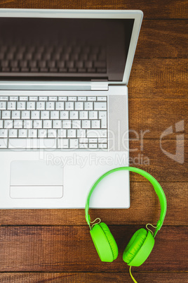 View of a grey laptop with a green headphone