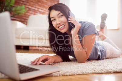 Asian woman using laptop on floor