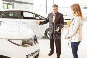 Salesman showing a car to a client