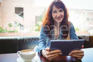 Mature student using tablet in cafe