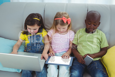 Happy kids sitting together with a tablet