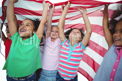 Girls standing with american flag overhead