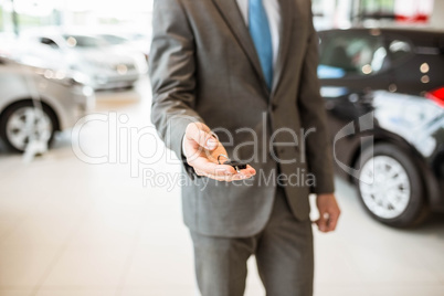 Close up of salesman giving a customer car keys