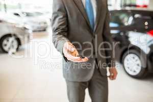 Close up of salesman giving a customer car keys