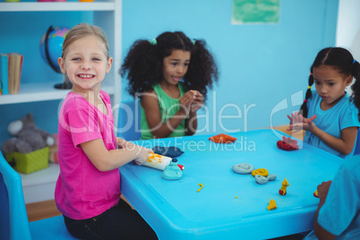 Smiling girls playing with modelling clay