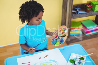 Child using paints to make a picture