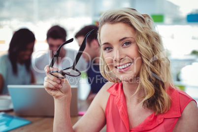 Smiling creative businesswoman working with co-workers