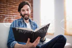 Casual man reading on his sofa