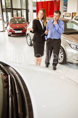 Smiling businesswoman showing car to customer