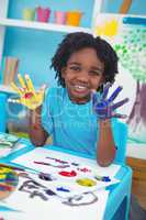 Happy kid enjoying painting with his hands