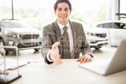 Smiling salesman ready to shake hand