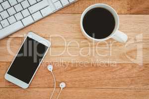 Black smartphone with cup of coffee